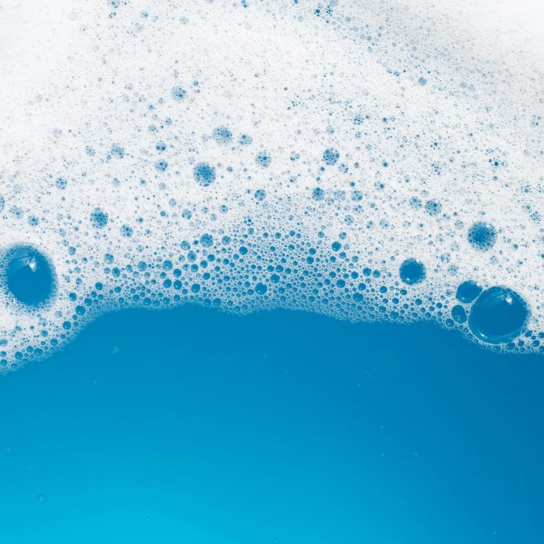 Bubbling ocean blue water with white foam, evoking the calming essence of the Ocean Breeze collection.
